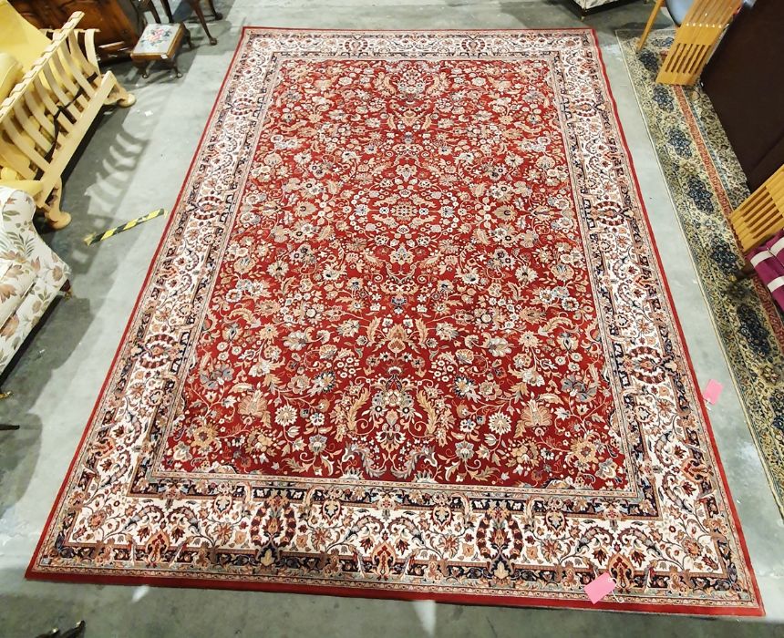 Modern red ground rug with allover foliate decoration, cream ground foliate decorated border,