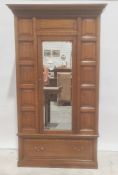 Early 20th century oak single door wardrobe, moulded cornice, panel decoration, mirror to door above