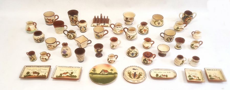 Large quantity of motto ware pottery including a toast rack, cups, jugs, egg cups, etc