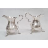 Two similar silver milk jugs with scroll handles, on shaped pad feet, one Birmingham 1959, the other