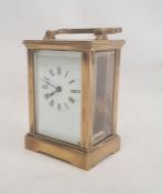 Brass and glass five-sided carriage clock with Roman numerals, bracket feet