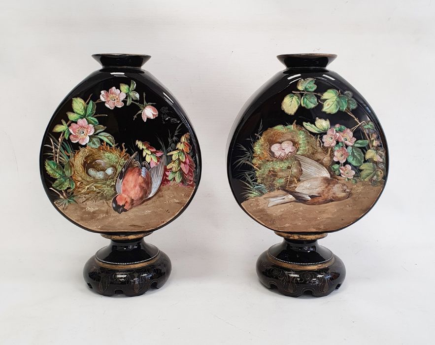 Pair of Victorian opaque black glass vases of shaped moonflask design, on circular pedestal bases,