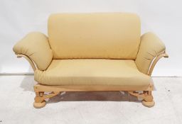 1960s/70s oak framed two seater sofa in pale yellow upholstery with adjustable scroll ends