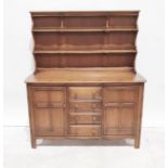 Ercol elm and hardwood dresser, two shelves above base of four drawers flanked by pair cupboards,
