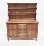 Ercol elm and hardwood dresser, two shelves above base of four drawers flanked by pair cupboards,