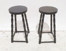 Two 20th century black painted stools