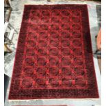 Modern Eastern-style red ground rug, the central field with elephant foot guls, stepped border