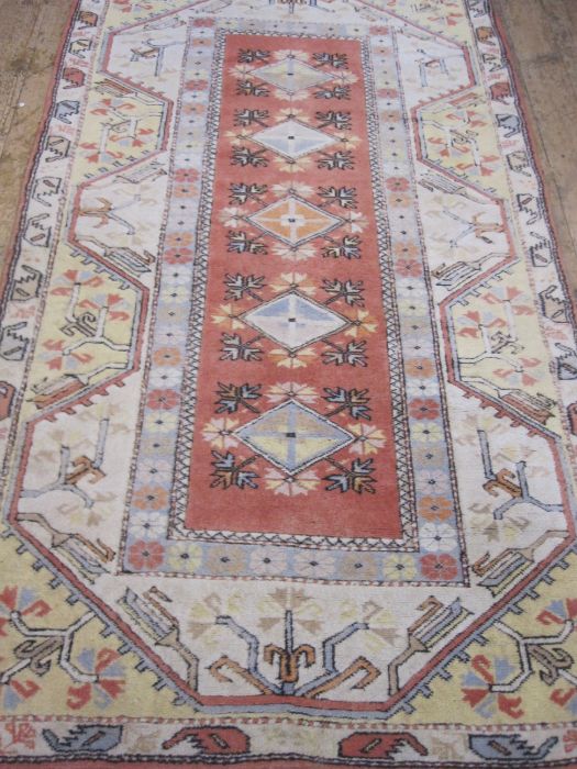 Oriental carpet manufacturer's wool rug in yellow, orange and blues, 216cm x 124cm