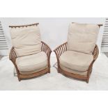 Pair of mid-elm Ercol armchairs with cream upholstered seat and backs