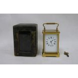 Brass and glass carriage clock with Roman numerals to the dial, in leather carry case