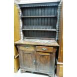 20th century oak Arts & Crafts-style dresser, the rack with moulded cornice above two shelves, the