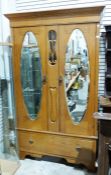 20th century oak Arts & Crafts-style two-door wardrobe with moulded cornice above two mirrored