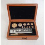 Graduated set of brass cylindrical weights up to 100g, with tweezers, in mahogany case, 14cm wide