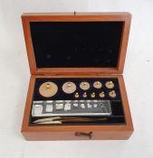 Graduated set of brass cylindrical weights up to 100g, with tweezers, in mahogany case, 14cm wide