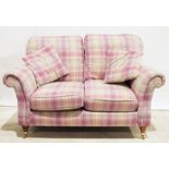 Modern two-seater sofa in pink tartan upholstery, on turned supports to brass caps and castors