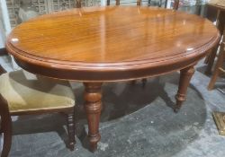 Oval mahogany extending table, moulded edge over turned supports, brown china castors