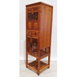Eastern-style narrow cabinet with assorted cupboard doors and drawers, a brass and wire nursery