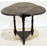 Dark stained triangular side table with drop-leaves, the whole with carved decoration, on turned and