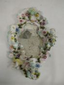 19th century porcelain wall mirror with three candle sconces, floral encrusted decoration and relief