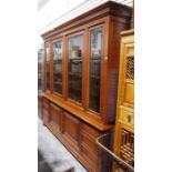 Large modern cherrywood bookcase with moulded cornice above four glazed doors enclosing shelves, the