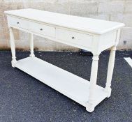 Cream painted hall table, the rectangular top with moulded edge above three drawers, on turned