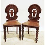 Pair of 19th century mahogany hall chairs with carved backs, shaped seats on turned front legs (2)