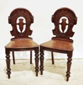 Pair of 19th century mahogany hall chairs with carved backs, shaped seats on turned front legs (2)