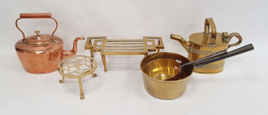 Two brass trivets, a brass watering can, a copper kettle and two brass saucepans