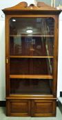 Early 20th century walnut cabinet, large glazed door enclosing shelves, over two cupboard doors