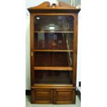 Early 20th century walnut cabinet, large glazed door enclosing shelves, over two cupboard doors