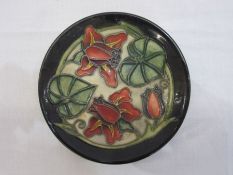 Moorcroft pottery pin tray with slip-trailed floral decoration, 12cm diameter