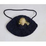 1920's evening bag with curled ribbon, embroidered interior, with a doll face with blond hair and