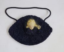 1920's evening bag with curled ribbon, embroidered interior, with a doll face with blond hair and