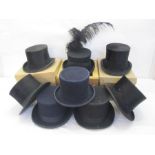 Eight various top hats, one trimmed as a funeral hat, one labelled 'Battersby & Co, London' and
