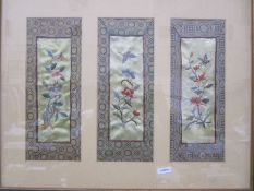 Three Chinese embroidered panels framed as one, depicting birds, flowers and insects within a