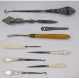 Silver-handed button hook, a silver-handled file, mother-of-pearl hooks, etc (1 box)