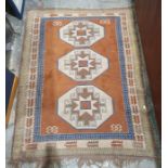 Eastern-style rug with three central medallions, on a brown ground, stepped border