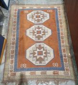 Eastern-style rug with three central medallions, on a brown ground, stepped border