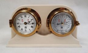 Sewills clock and barometer mounted in ship's brass bulkhead-type surround