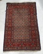 Eastern-style red ground rug with foliate decoration to the central field