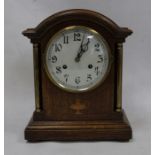 Oak-cased mantel clock with arched top, Arabic numerals to the dial, on plinth base