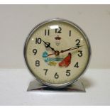 Chrome and green metal keywind clock with animated pecking chicken to the dial, marked 'Shanghai,