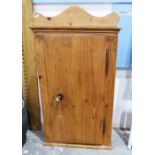 Vintage pine wall-hanging single door cabinet, the single door opening to reveal assorted shelves