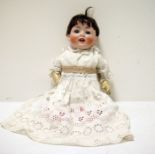 A bisque head baby doll, with composition body, closing eyes and open mouth, marked to back of