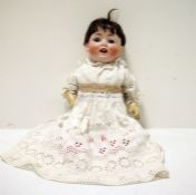 A bisque head baby doll, with composition body, closing eyes and open mouth, marked to back of