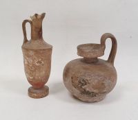 Pottery vessel of circular form with loop handle, 12cm high and a pottery ewer with traces of