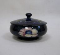Moorcroft lidded powder bowl with blue ground floral decoration, oblate, with paper label 'W