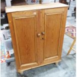 Late 19th/early 20th century pine two-door cabinet, the two panelled doors enclosing shelves, on