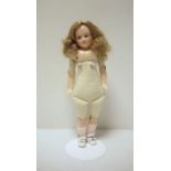 Waxed shoulderhead doll with inset green glass eyes, soft body with waxed lower limbs, 42cm high