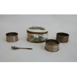 Three silver napkin rings and a porcelain snuff box of oval form, the top of the hinged cover